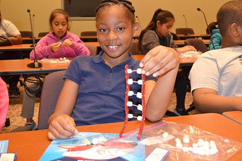 IPA student showing off the DNA model that she made during one of the activities.