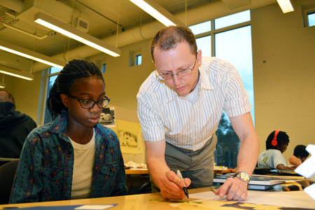 Teacher helps student during a session of the camp.