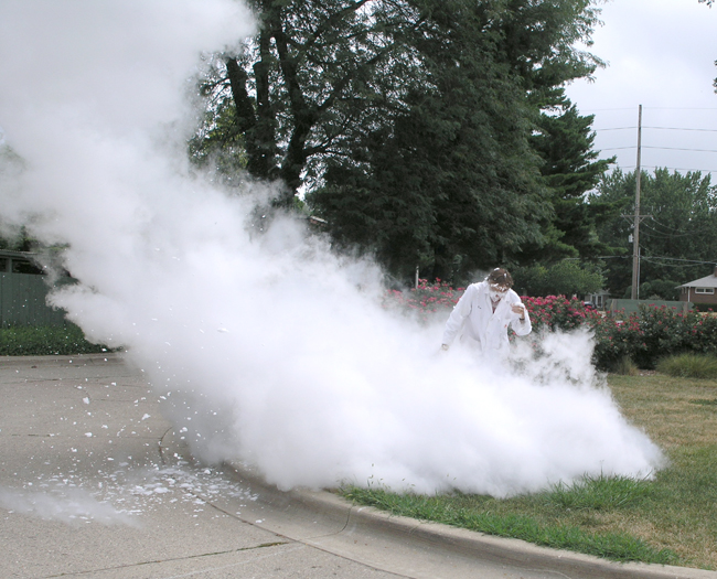 Don Decoste just after pouring liquid nitrogen into a container, to cause an "eruption" of vapor and suds.