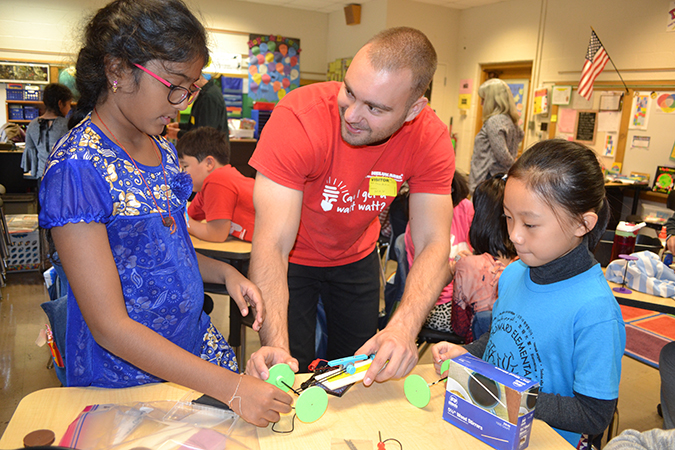 George Popovic (center) helps two students work on their solar cars.