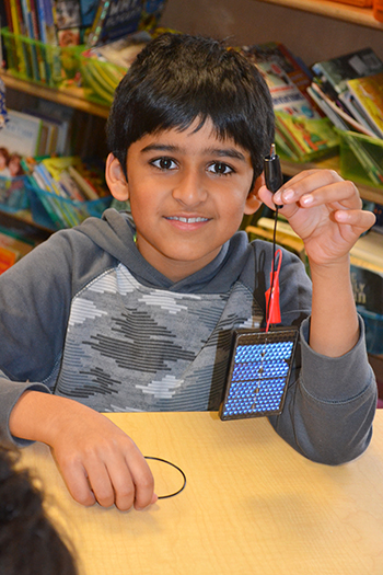 A Dr. Howard School student showing the solar cell he will use to power his solar car.