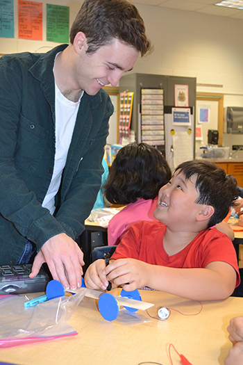 Cameron Harris (left) helps a student build his solar car.