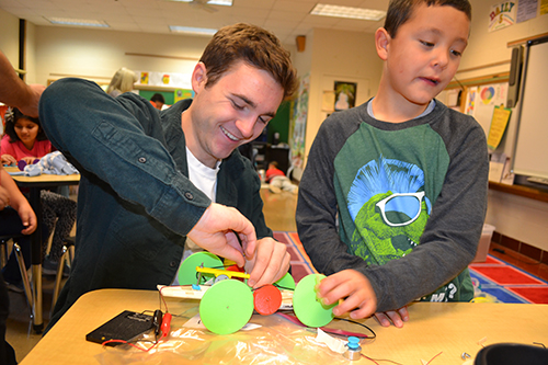 Cameron Harris helps a fourth grader with his solar car.