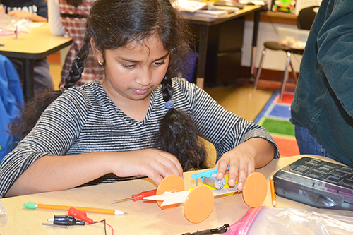 A Dr. Howard school student works on building her solar car.