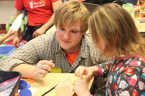 Peter Sokalski (left) helping a fourth grader build her solar car. (Image courtesy of Joe Muskin.)