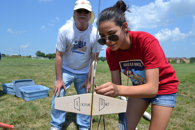 GAMES camper prepares rocket for launch.