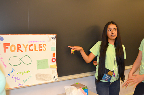 A high school student presents her team's design project at the end-of-the-camp poster session.