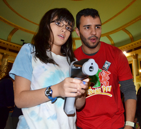 Local youngster and <em>Illinois</em> grad student and SACNAS member use an infrared thermometer to measure the temperature of a  hot spring simulation.