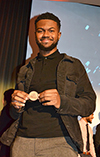 Amaury Saulsberry, a member of the winning team who dreamed up Nouvou, the Smart Pacifier, shows off their prize, a 