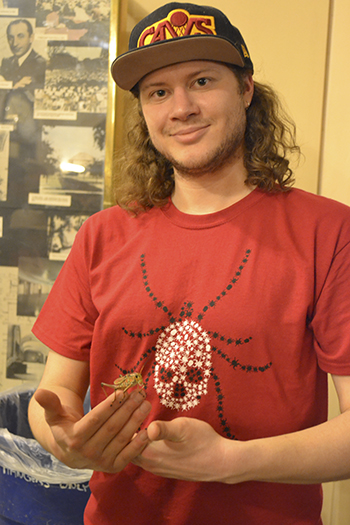 Entomology PhD student and EGSA president Charles Dean holds a grasshopper.