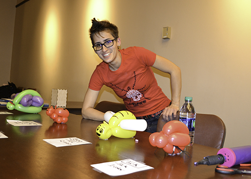 An entomology Ph.D. student helping out at the balloon insects station shows the balloon insects kids could have made for themselves—all of which she designed