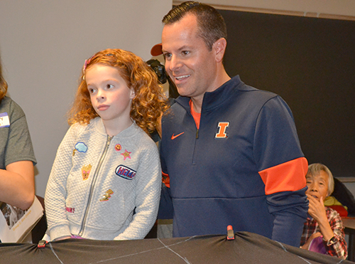 Barry Houser and his daughter learn about orbits and prepare to toss marbles to simulate orbits during the Orbit Simulator exhibit.