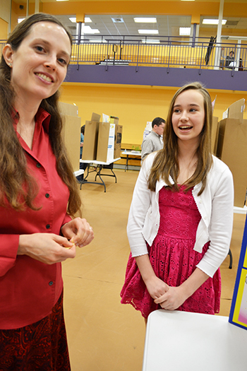 Carrie Kouadio (left) interacts with a student at a local science fair Kouadio helps organize.