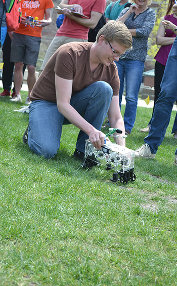 An ME370 student performs an intervention: he's picking up his walker, which kept falling over due to the terrain.