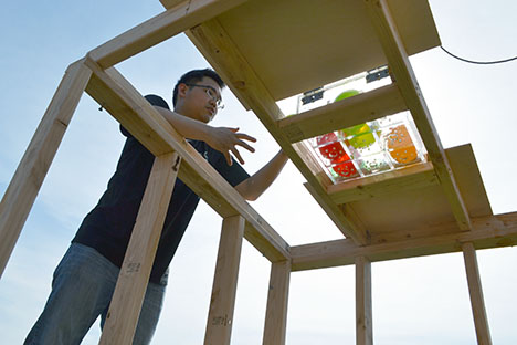 ME370 student carefully places water baloons in the dunking booth.