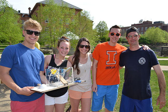 Team of CE370 students show their BLAM design which allowed them to successfully dunk two professors, including Davin Horn (right).