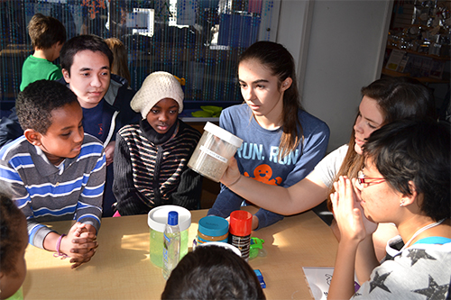 Three Uni High students (right) teach a group of MLK students about funny fluids.
