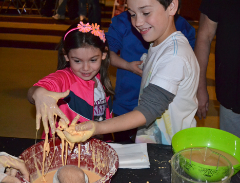 Two youngsters appreciate the ooey-gooey qualities of oobleck.