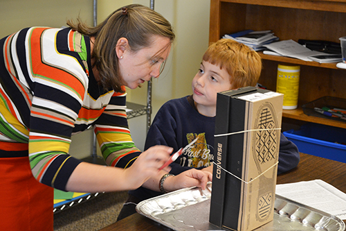 Nelson helps a STEAM student build his sling psychrometer.