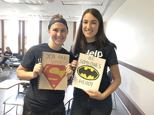 Left to  right: SWE members </strong>Taylor Wills and Dionora Osmani hold notebooks they made  out of one-sided recycled white paper, complete with a cereal box or cardstock cover, which  they decorated themselves, as part of SWE's Project Paplet. (Image courtesy of Berat Gulecyuz.)