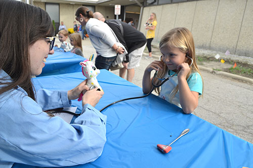 A local kindergartener uses a stethoscope to “listen” to her unicorn’s heart.