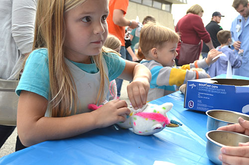 The youngster cleans the spot on the unicorn where the surgery will take place.