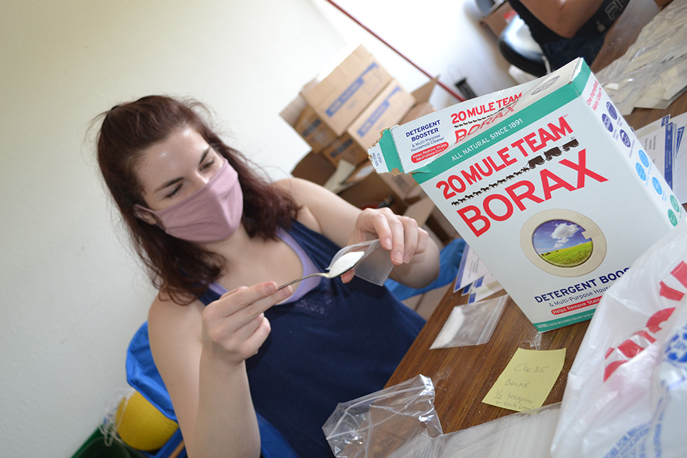 During the Saturday kit-making session, a volunteer adds Borax to a packet to be used in the Non-Newtonian Fluids hands-on activity.
