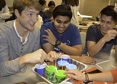 Joy Chen helps a team of high school students complete their hands-on activity.