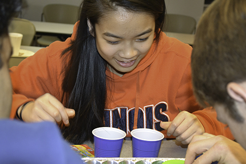 Joy Chen helps a team of high school students complete their hands-on activity.