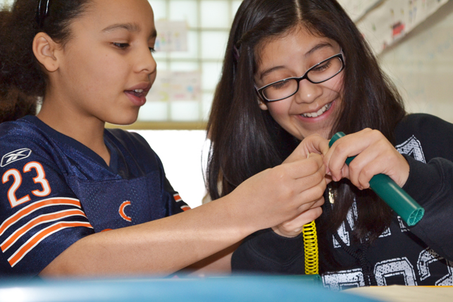 Two edison middle school girls work together to create a model of their design.