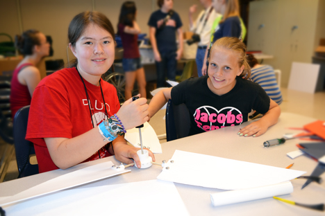 Two campers assemble their wind turbine.
