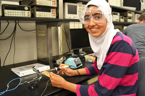 GLEE camper takes a break from soldering her circuit.