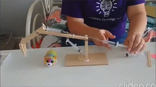 A camper builds a hydraulic machine during an ABE hands-on activity