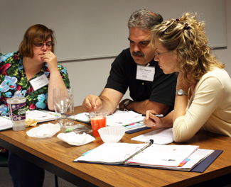 Science teachers at iRISE teacher workshop perform experiment filtering water.