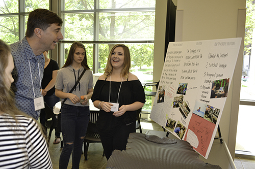 MechSE's Joe Muskin (upper left) looks on as a Centennial student explains about her team's research during the IRISE 2017 Symposium held last spring.