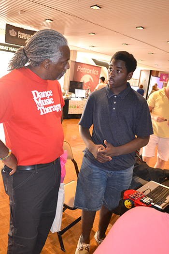 DJ Jackson (right), Centennial sophomore, interacts with a visitor at the Pygmalion Festival