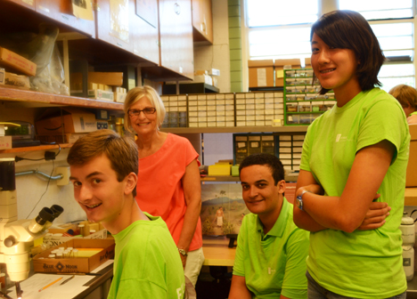 Archeologist and a few of the campers during instruction about using a microscope.